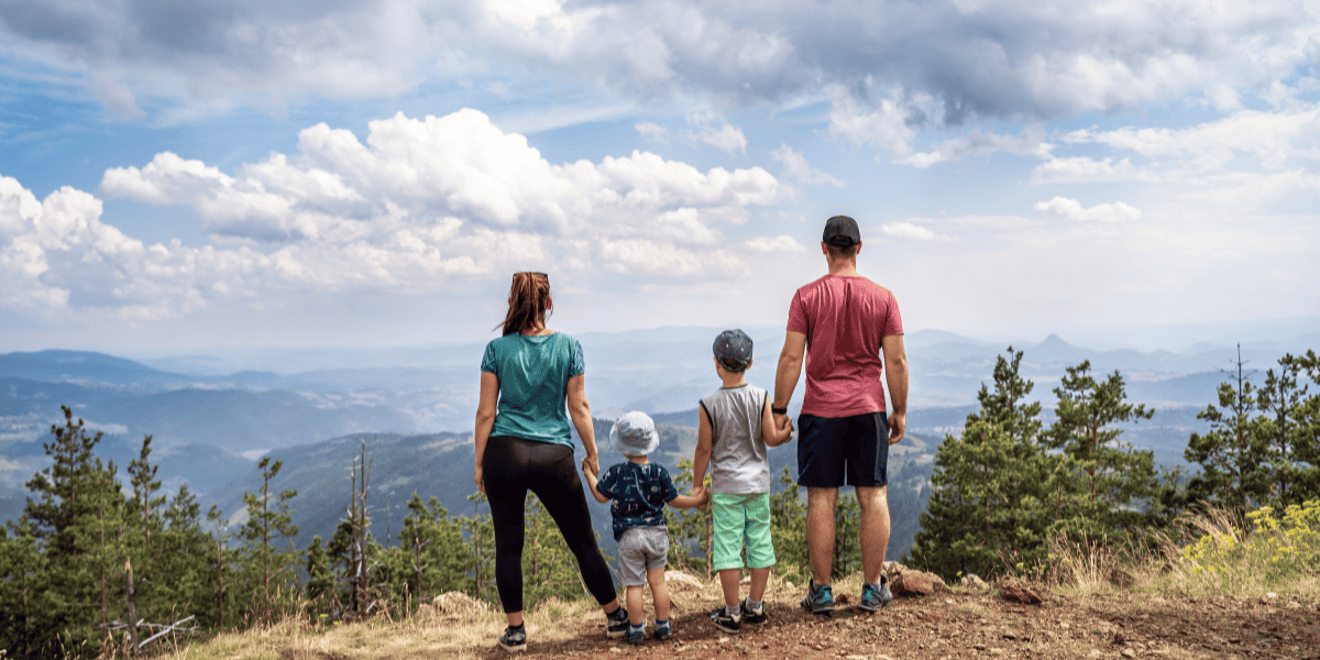 family of four standing on top of a mountain