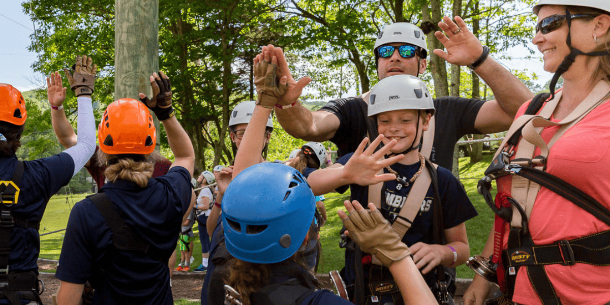 family highfiving and cheering after their aerial adventure course