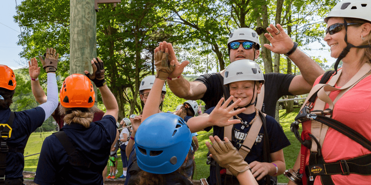 group of people high-fiving after ziplining