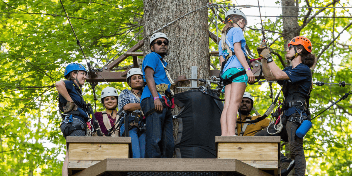 group of people standing on a zipline platform