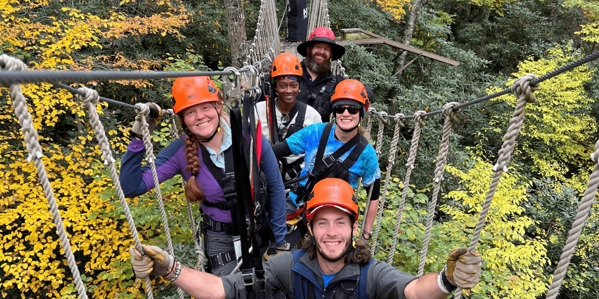 group of people ziplining in the fall